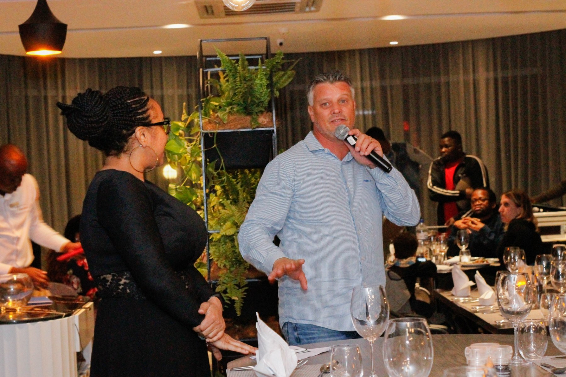 Speakers addressing guests at an indoor event